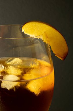 Şeftali dilimiyle süslenmiş taze buzlu içecek.