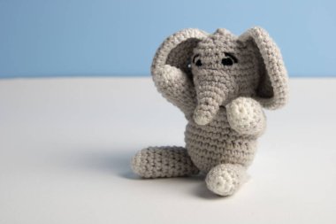 Tığ işi gri fil oyuncağı masada oturuyor.