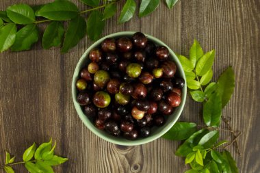 Taze jabuticaba üzümleri yeşil kasede dinleniyor.