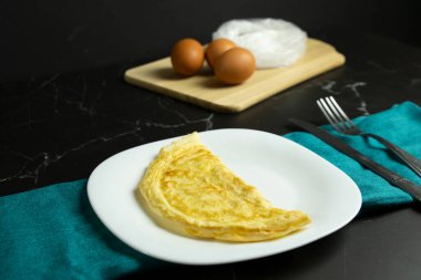 Beyaz tabakta duran altın omlet.