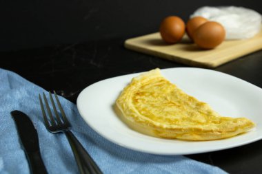 Beyaz tabakta duran altın omlet.