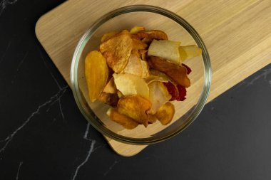 Cam kasenin içinde çeşitli sebze cipsleri var.