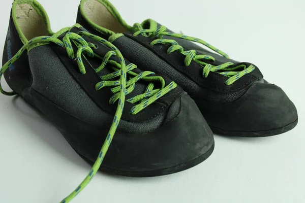 Yeşil bağcıklı siyah tırmanma ayakkabıları birlikte dinleniyor.