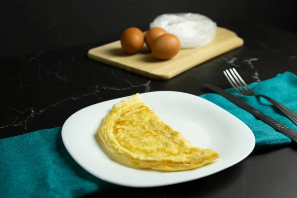Beyaz tabakta duran altın omlet.