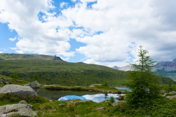 Panorama da montanha italiana, nuvens refletidas no lago alpino — Fotografia de Stock