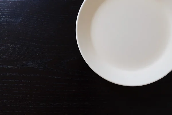 Placă albă goală pe masă neagră din lemn — Fotografie, imagine de stoc
