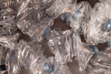 Plastik şişelerin arka planı. Siyah yüzeyde boş şişeler. Geri dönüşümsüz atık