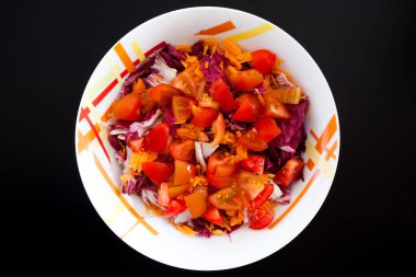 Siyah masada havuçlu ve domatesli salata. Gıda arkaplanı