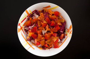 Siyah masada havuçlu ve domatesli salata. Gıda arkaplanı