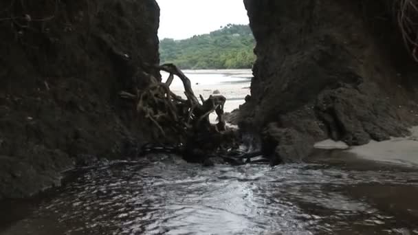Water Rushing Through Rock Formation on Beach — Stock Video
