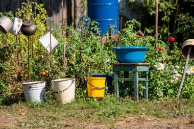 Kovalar, eski alüminyum ve yazın yeşil arka planda demir tencereler. Köylülerin kırsal yaşamı.