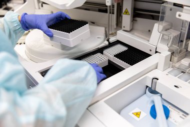 Bir kadın tıbbi malzemeler üzerinde analiz yapar. Covid-19 virüsüne karşı yeni bir aşı geliştirildi. Tıbbi laboratuvar. Laboratuar tıbbının kalite kontrolü.