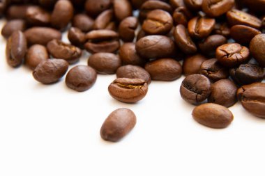 Kavrulmuş kahve çekirdekleri beyaz arka planda izole edilmiş.