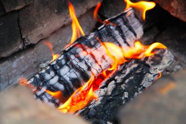 Kırmızı renkte parlayan közler, soyut arka plan. Yanan odun ateşinin sıcak közleri. Yakacak odun ızgarada yanıyor. Doku ateş közleri.