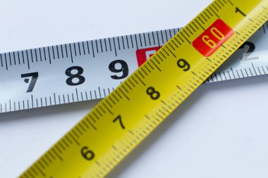 Beyaz arka plan bantlarındaki beyaz ve sarı şeritler santimetre cinsinden kesişiyor.