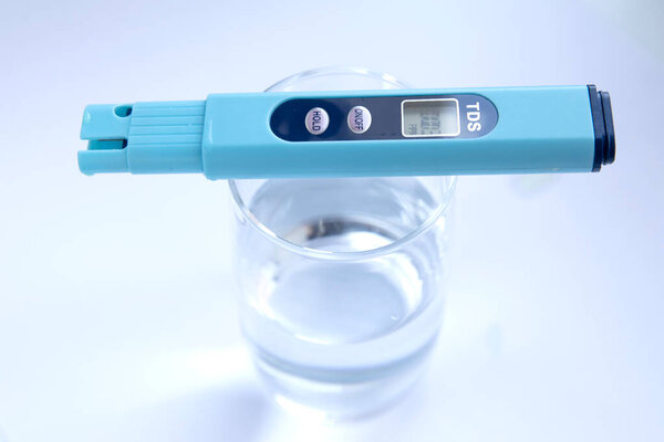 TDS измерение воды. Электронный рН-метр в стакане воды.