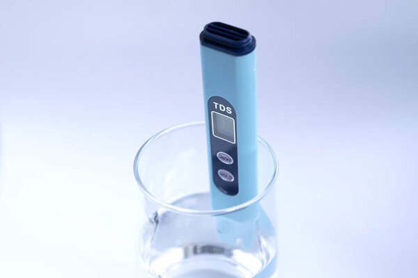 TDS измерение воды. Электронный рН-метр в стакане воды.
