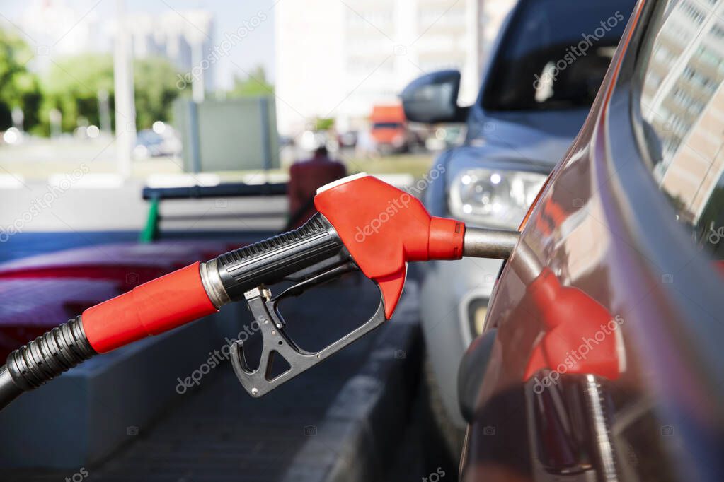 Refueling a car at a gas station. Refueling a car in the city. Blurred background with car