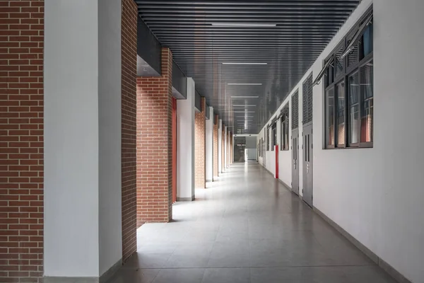 Empty long corridor in modern school building.