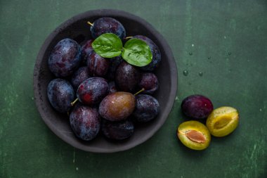 Yeşil arka planda bir tabakta taze kuru erik