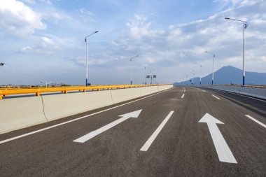 Şehir silueti olan boş asfalt karayolu.