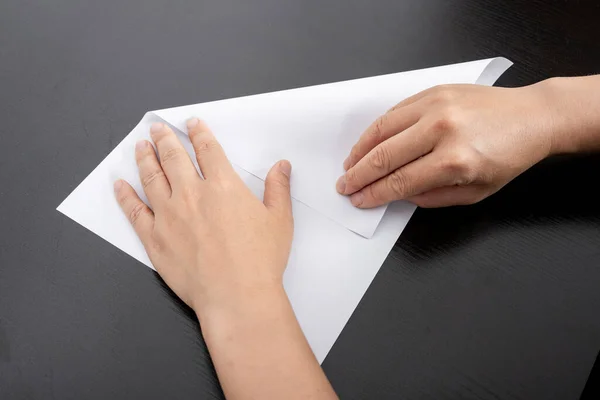 A woman is folding paper.