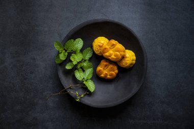 Ay çörekleri koyu gri arka planda izole bir tabakta. Geleneksel Çin Pastası, Sonbahar ortası Ay pastası, sufle.