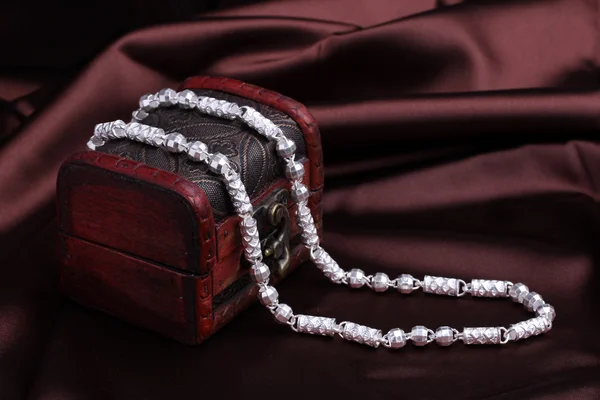 Серебряное ожерелье на шелковом фоне — стоковое фото