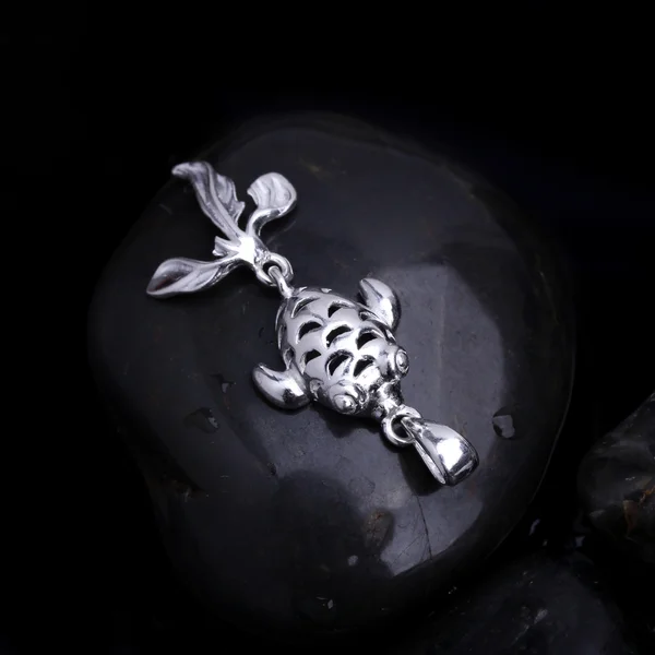 Gümüş süs balığı kolye siyah taş arka plan — Stok fotoğraf
