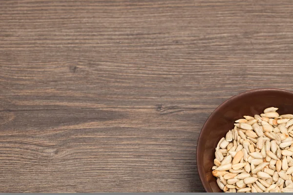 A ceramic bowl full of Seeds over old wood background — Stock Photo, Image