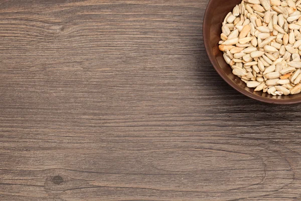 A ceramic bowl full of Seeds over old wood background — Stock Photo, Image