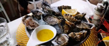 Buzlu deniz ürünleri, istiridye, limon ve sos, tabakta deniz ürünleri.