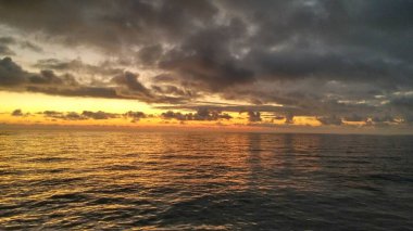 Denizde gün batımı, günbatımında gökyüzünde bulutlar
