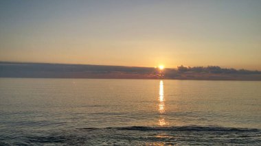 Denizde gün batımı, günbatımında gökyüzünde bulutlar