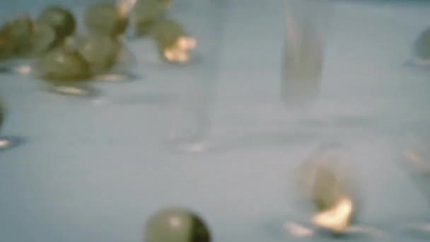 Κάψουλες συμπλήρωμα που χύνεται επάνω στην επιφάνεια — Αρχείο Βίντεο