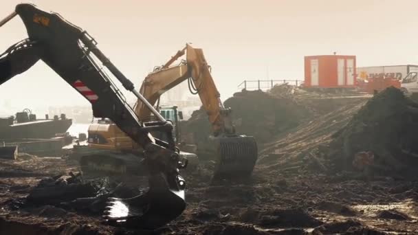 Экскаваторы, раскапывающие строительную площадку — стоковое видео