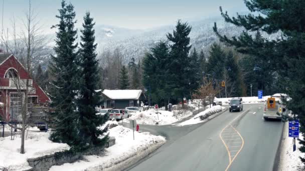 Voertuigen op weg In de besneeuwde berg stad — Stockvideo