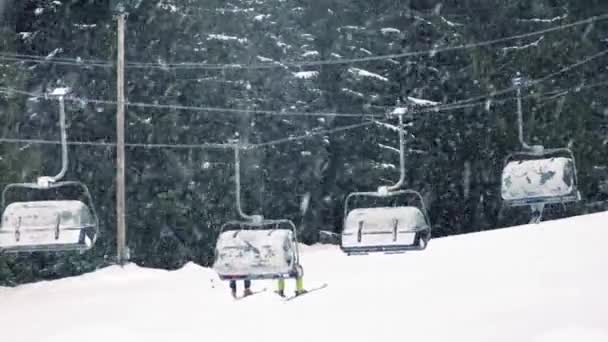 Esquiadores en telesilla con nieve cayendo — Vídeos de Stock