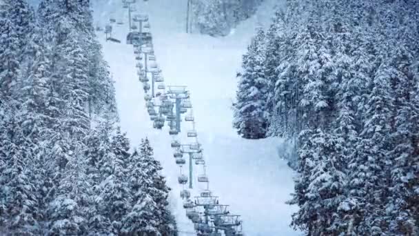 Liften går upp berg med snö som faller — Stockvideo