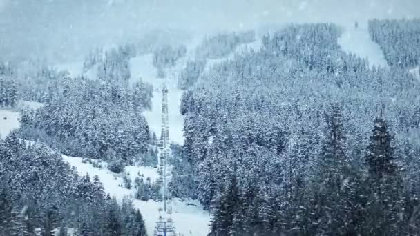 Skidliften upp berg med snö som faller — Stockvideo