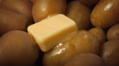 Tereyağı sıcak patateslerin üzerinde eriyor.