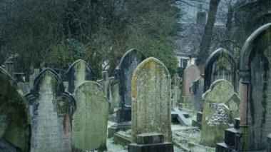 Kışın hafif kar yağışında bir mezarlık