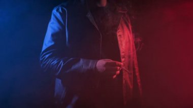 Neon ışıklarında ve sislerde sigara içen adam