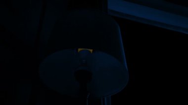 Pencerenin yanındaki lamba gece açılıp kapanıyor.
