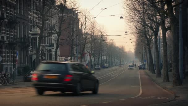 Carros e bicicletas na cidade ao pôr do sol — Vídeo de Stock