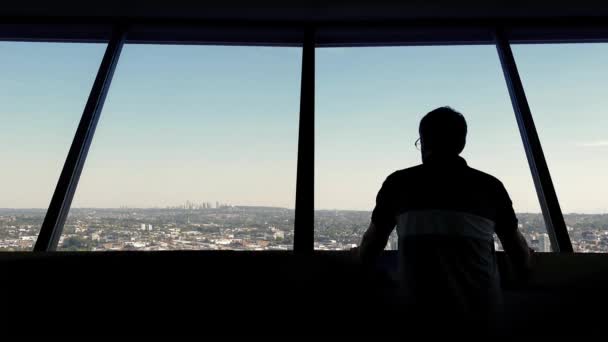 L'uomo guarda la città dal ponte di osservazione — Video Stock