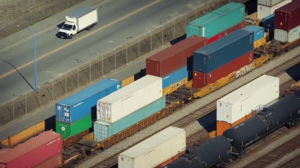 Carros que passam jarda de estrada de ferro com Boxcars — Vídeo de Stock