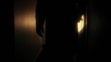 İnsan el feneriyle binanın içine bakıyor.
