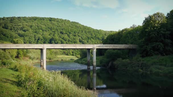 Auto kruist brug Over rivier In zonnige vallei — Stockvideo