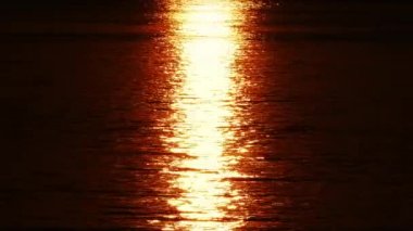 Parıldayan su yüzeyine yansıyan güneş